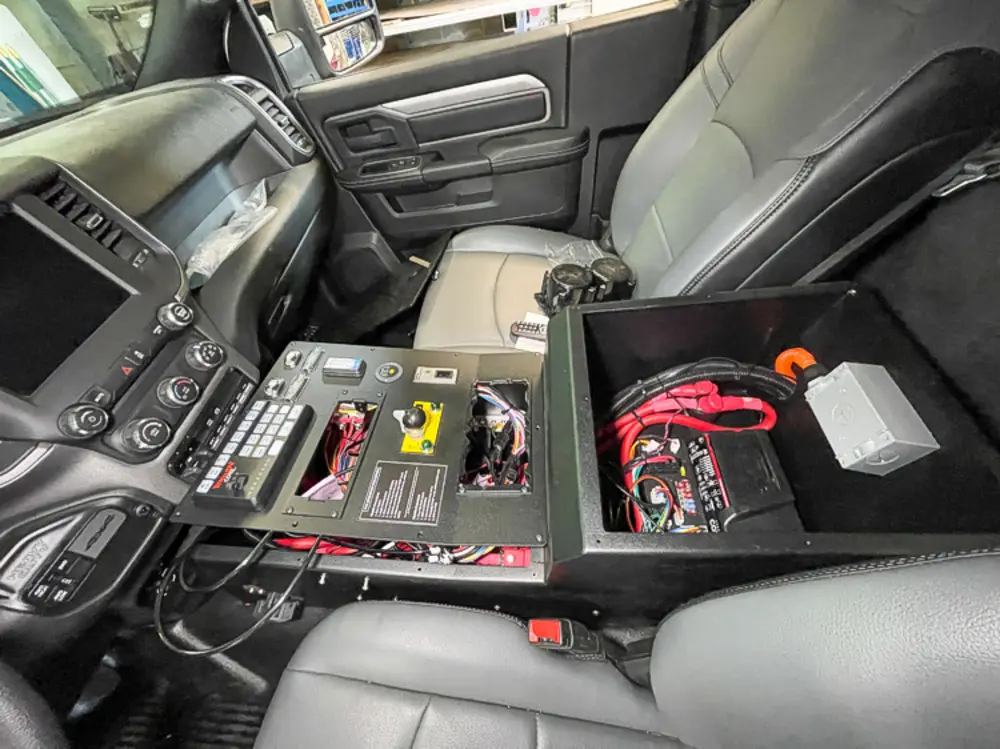 Exterior view of small fire truck showing cab, body compartments, and wheel/tire area.